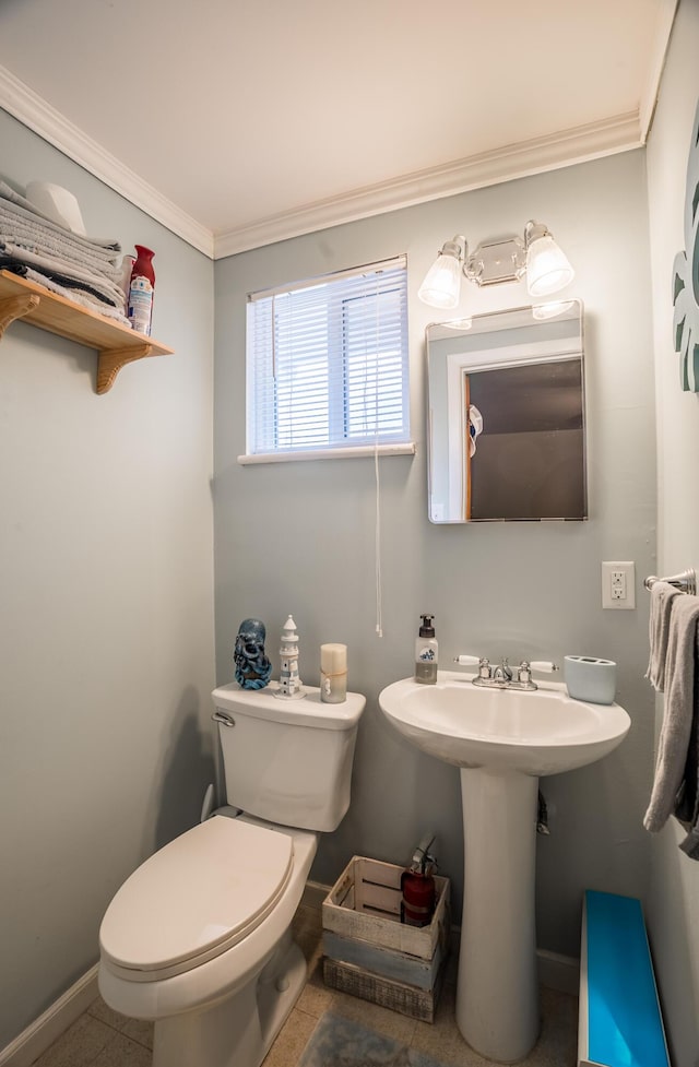 bathroom with baseboards, toilet, and crown molding