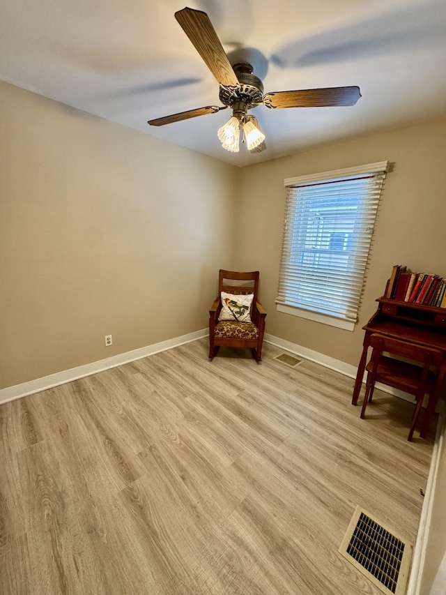 living area with ceiling fan and light hardwood / wood-style floors