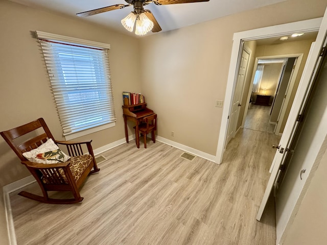 living area featuring light hardwood / wood-style flooring and ceiling fan