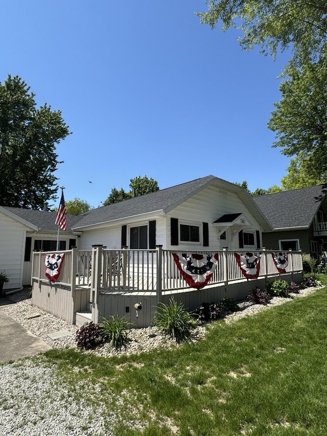 view of front facade featuring a wooden deck and a front lawn