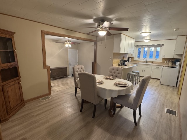 dining room with sink and light hardwood / wood-style flooring