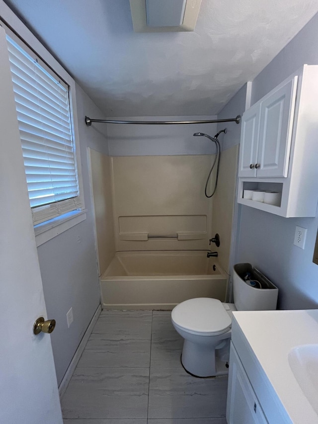 full bathroom featuring toilet, marble finish floor, bathtub / shower combination, and vanity