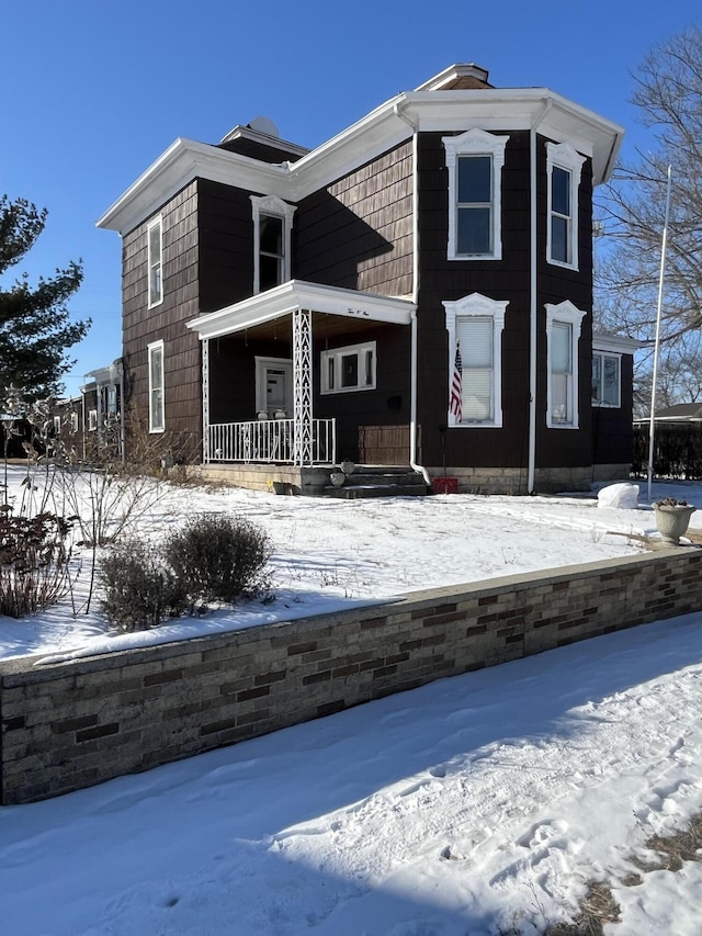 snow covered property with a porch