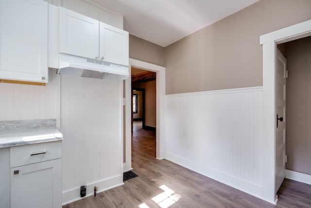 1704 Highland Ave, Springfield, OH 45503 - kitchen featuring under cabinet range hood, light countertops, light wood-style flooring, wainscoting, and white cabinetry