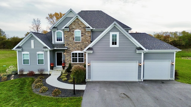 view of front of home with driveway, a shingled roof, stone siding, and a front lawn