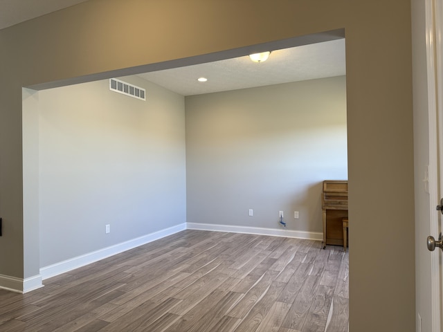 unfurnished room with recessed lighting, baseboards, a textured ceiling, visible vents, and wood finished floors