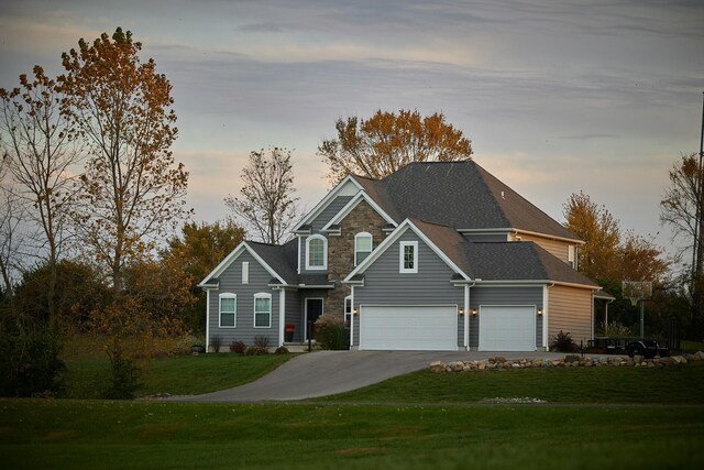 view of front of house with concrete driveway, an attached garage, and a yard
