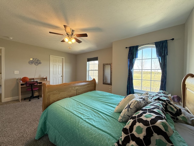 bedroom with multiple windows, ceiling fan, carpet flooring, and a textured ceiling
