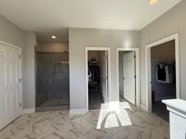 full bathroom with baseboards, marble finish floor, and a shower stall