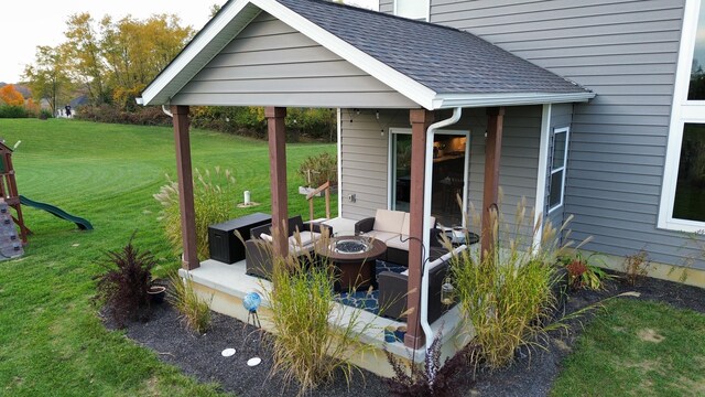 exterior space with a lawn, a patio, and a fire pit