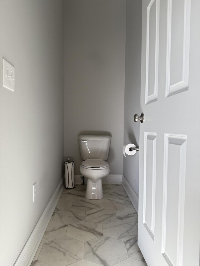bathroom with baseboards, marble finish floor, and toilet
