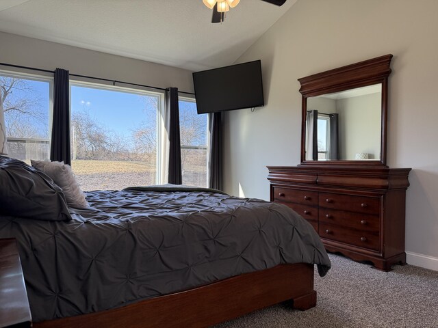 carpeted bedroom featuring baseboards, lofted ceiling, and ceiling fan