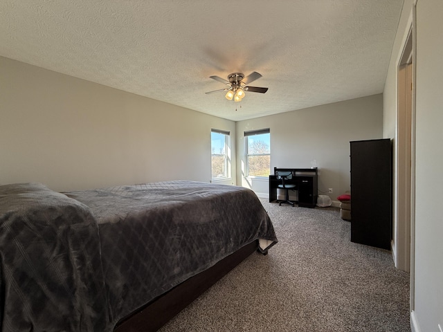 bedroom featuring carpet flooring, ceiling fan, and a textured ceiling