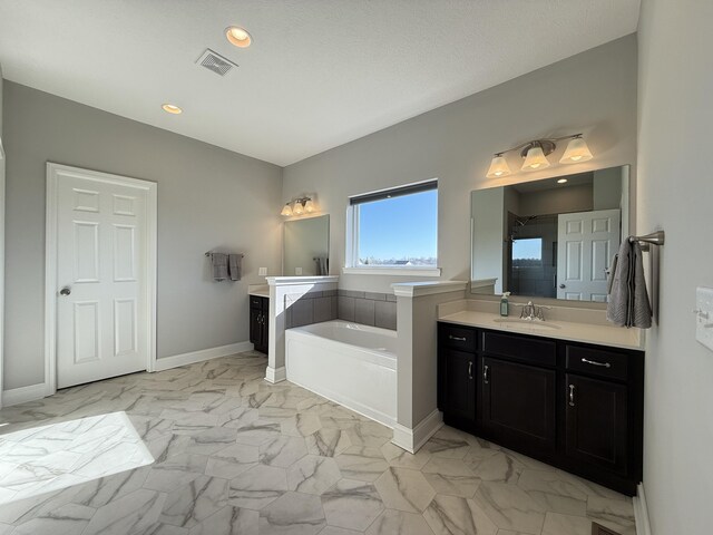 bathroom featuring a bath, visible vents, marble finish floor, two vanities, and a sink