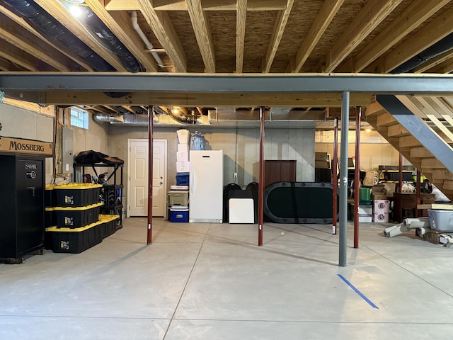 unfinished below grade area with freestanding refrigerator, stairway, and electric panel