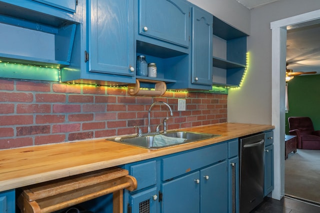 kitchen with blue cabinets, dishwasher, butcher block counters, sink, and ceiling fan