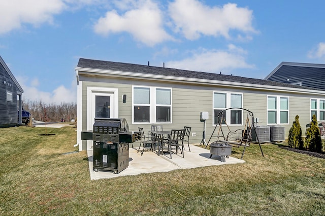 back of property with a patio, an outdoor fire pit, central AC unit, and a lawn