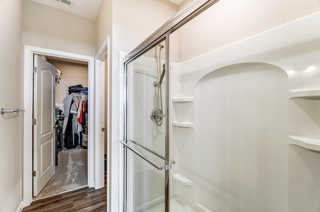 bathroom featuring wood-type flooring and a shower with shower door