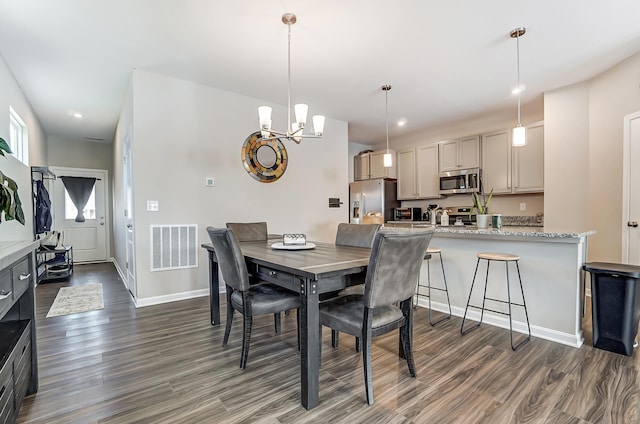 dining area with a notable chandelier and dark wood-type flooring