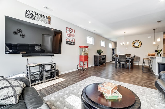 living room featuring an inviting chandelier and dark hardwood / wood-style floors