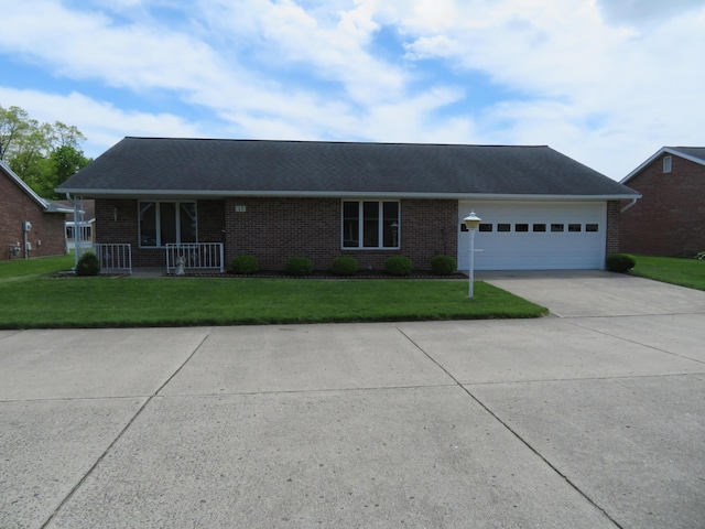 609 Julia St Unit 17, Urbana, OH 43078 - ranch-style house with brick siding, concrete driveway, a front yard, an attached garage, and covered porch