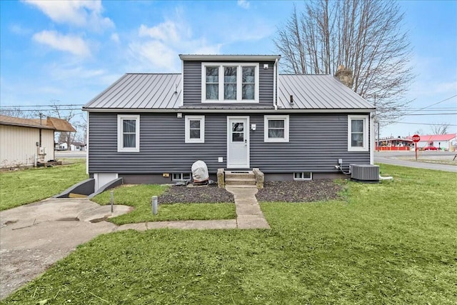 rear view of house featuring a lawn, metal roof, and cooling unit