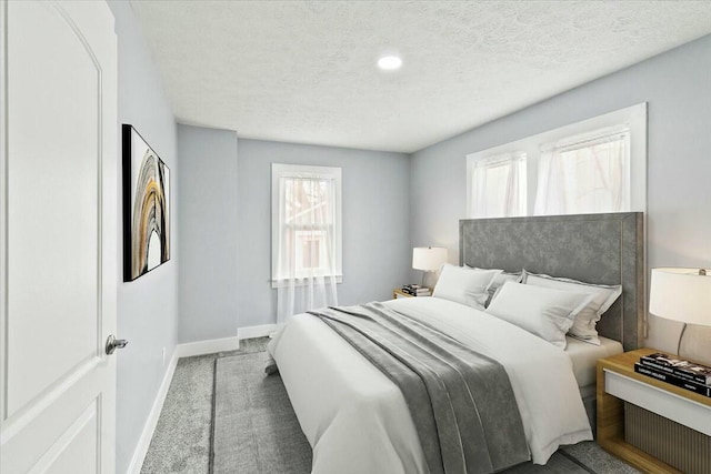bedroom featuring baseboards, carpet flooring, and a textured ceiling
