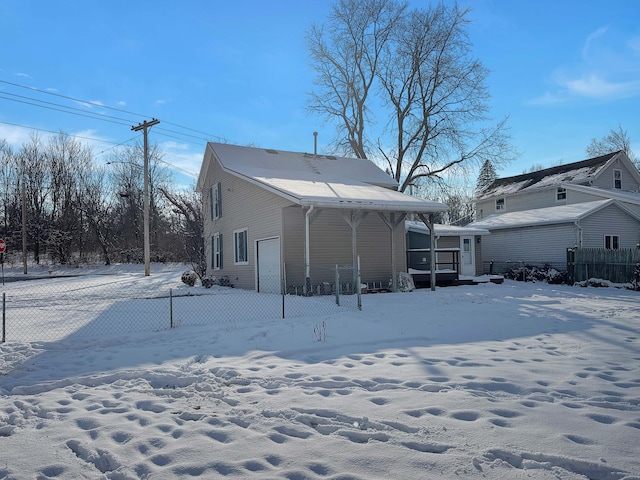 snow covered house with fence