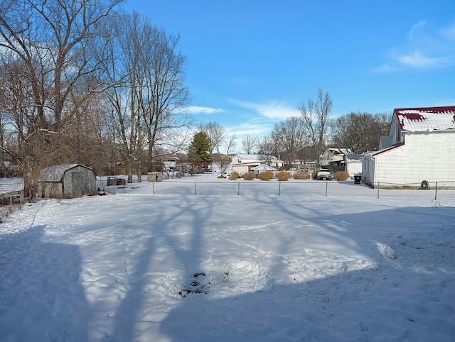 yard covered in snow featuring a storage unit and an outbuilding