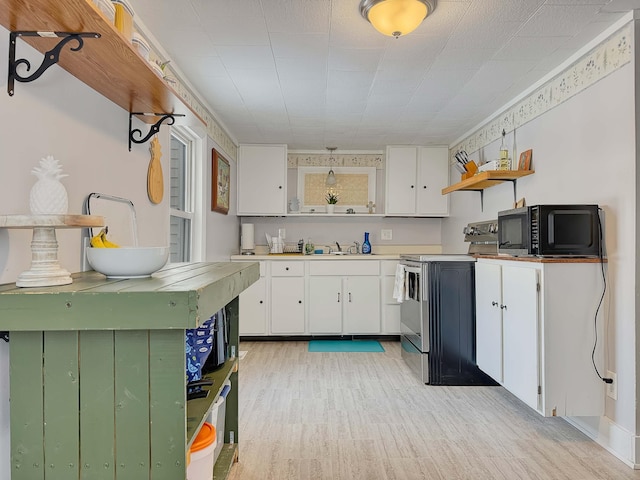 kitchen featuring black microwave, a sink, white cabinets, stainless steel electric range, and open shelves