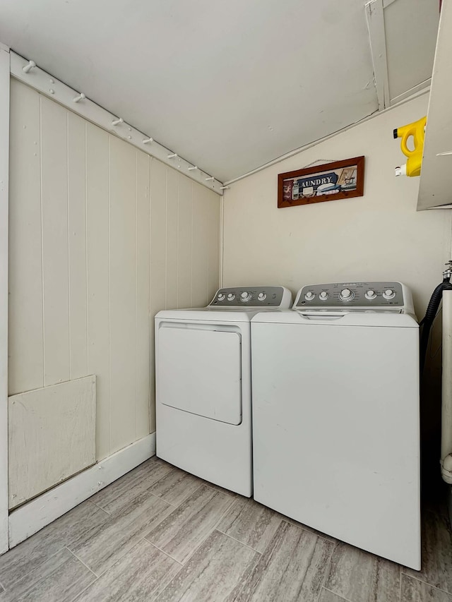 laundry room with laundry area, washing machine and dryer, and light wood finished floors