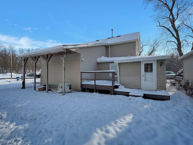 snow covered property featuring fence and a deck