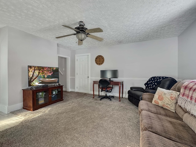 living room featuring a textured ceiling, carpet, a ceiling fan, and baseboards