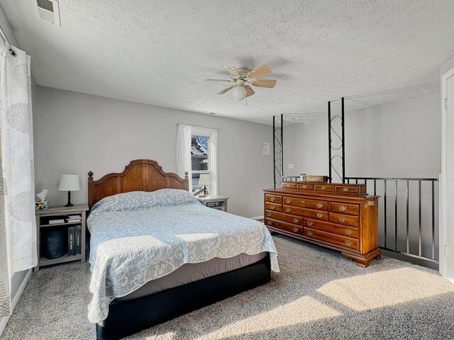 bedroom featuring a textured ceiling, carpet floors, ceiling fan, and visible vents