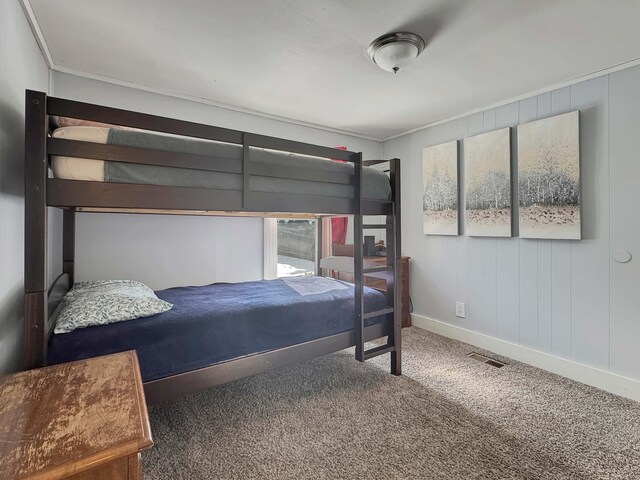 bedroom with carpet, crown molding, visible vents, and baseboards