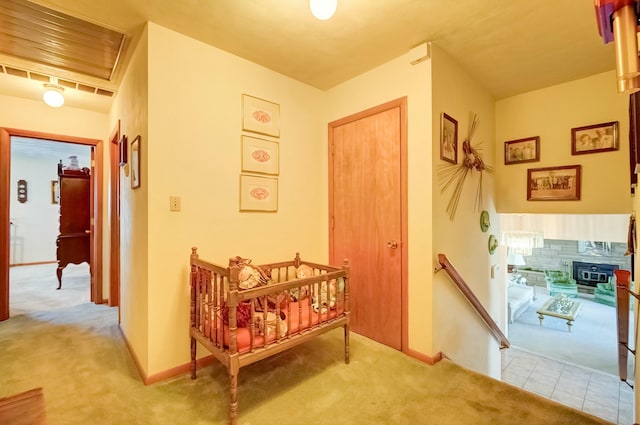 corridor with tile patterned floors, baseboards, an upstairs landing, and carpet flooring