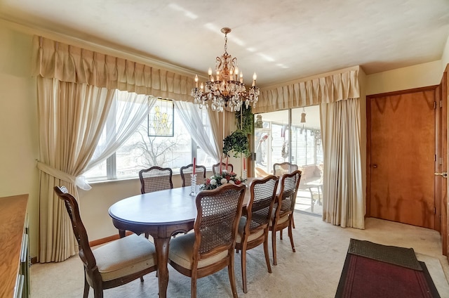 dining room featuring light colored carpet and an inviting chandelier