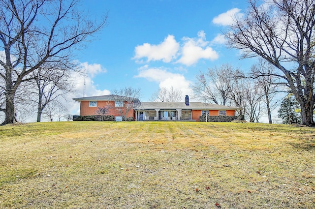 view of front of home featuring a chimney and a front yard