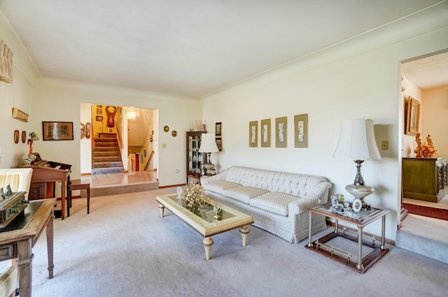 living area featuring baseboards, carpet, and stairs