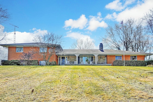 view of front facade with a front lawn, brick siding, and a chimney