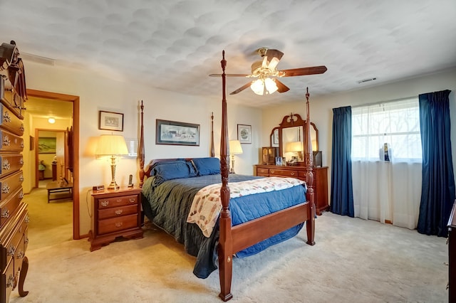 bedroom featuring visible vents, light colored carpet, and a ceiling fan