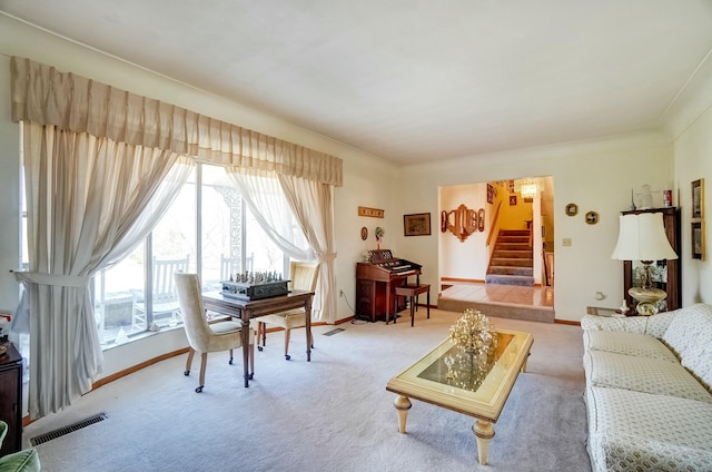 living area with visible vents, light carpet, baseboards, and stairs