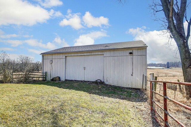 view of pole building featuring a lawn and fence