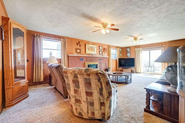 living room featuring a textured ceiling, a fireplace, a wealth of natural light, and light carpet