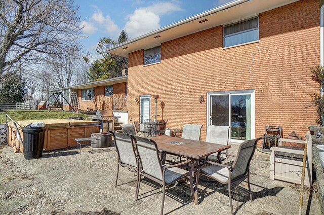 view of patio with outdoor dining area and a hot tub