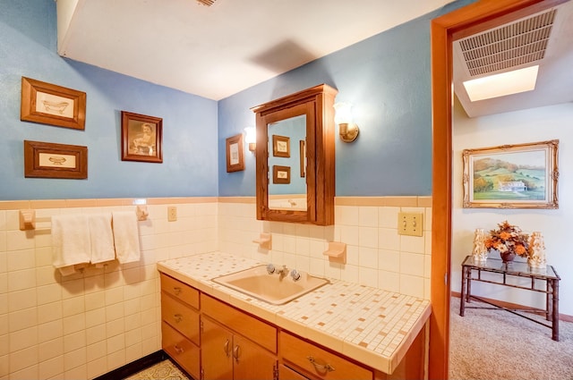 bathroom featuring visible vents, tile walls, wainscoting, and vanity