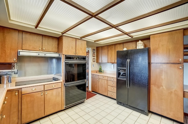 kitchen featuring black appliances, light countertops, brown cabinets, and under cabinet range hood