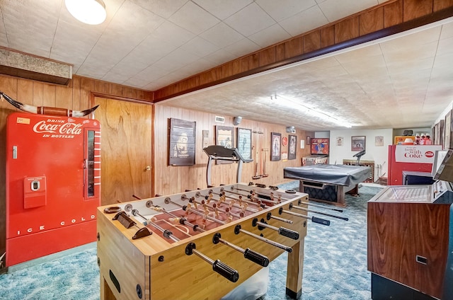 rec room with carpet and wooden walls