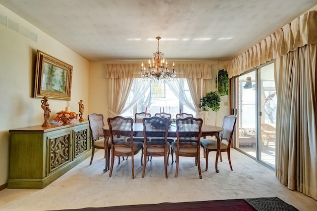 dining space with visible vents, light colored carpet, and a chandelier