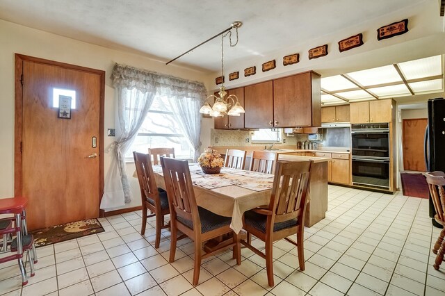 dining room with a chandelier and light tile patterned flooring